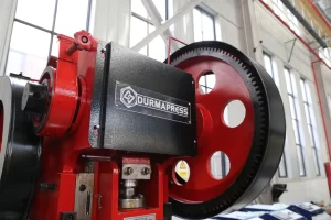 Hydraulic punch press operating in a metal fabrication workshop