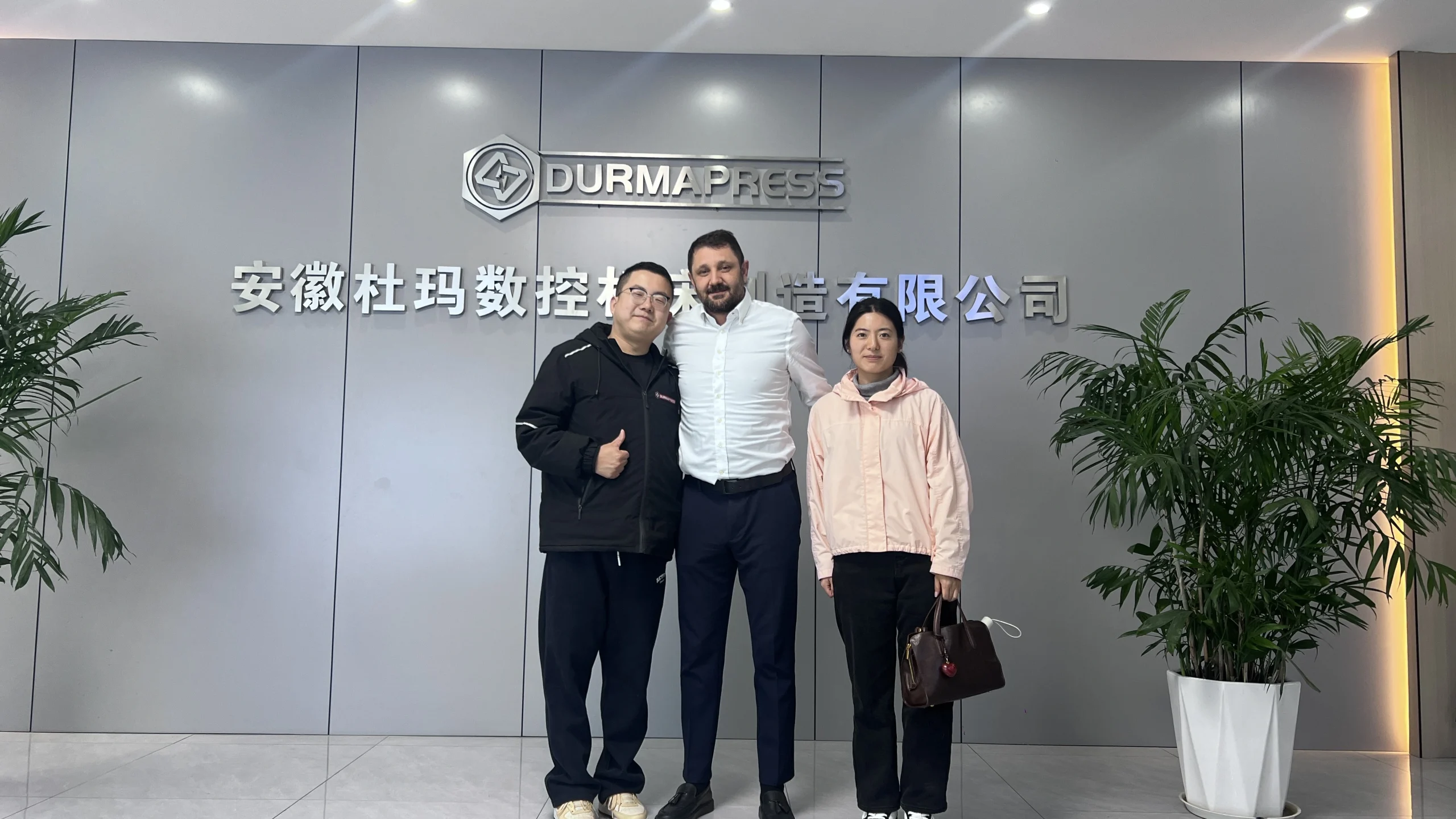Turkish client and Durmapress staff standing at factory entrance