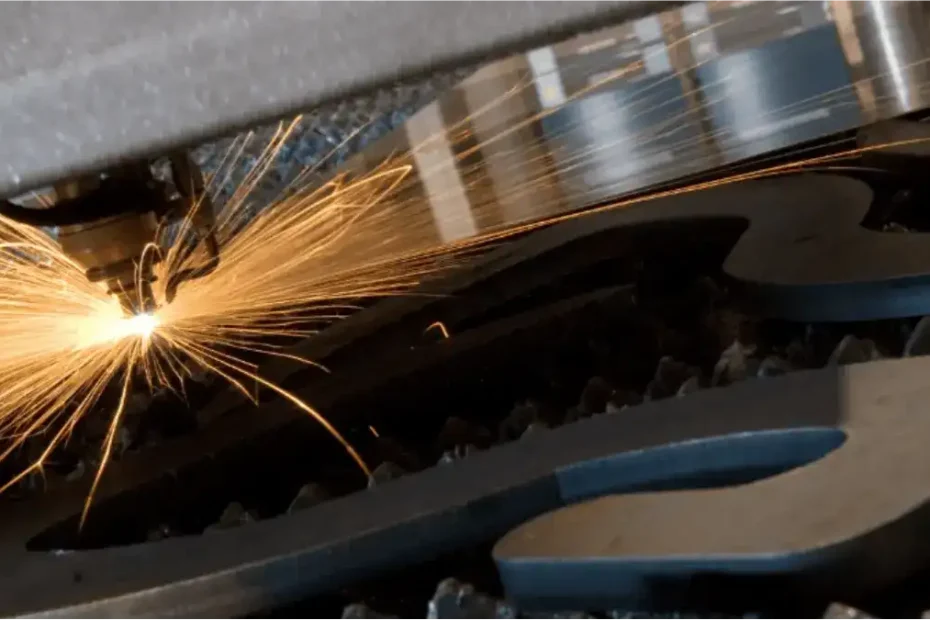 Fiber laser cutting a steel sheet, showing the narrow kerf channel left along the cut line